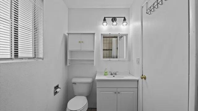a bathroom with a toilet sink and mirror