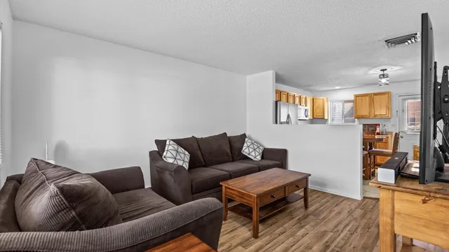 a living room with furniture and a wooden floor