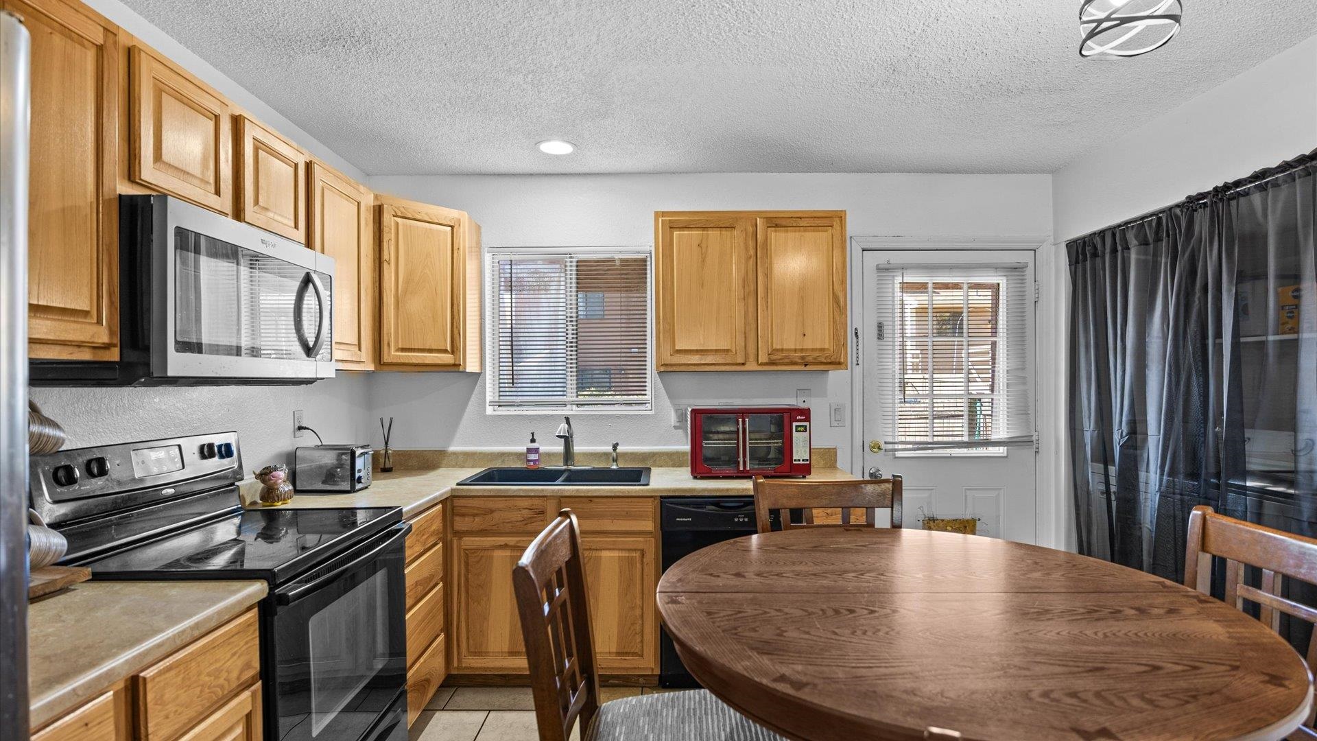 510 Coronado Court, Unit R Clifton, CO 81520 - Photo 7 of 20 a kitchen with stainless steel appliances granite countertop a stove a sink a microwave a dining table and chairs