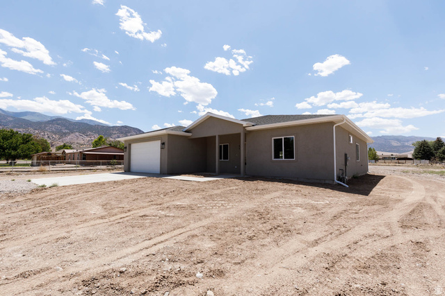 51 West 500 South Monroe, UT 84754 - Photo 3 of 41 Single-story residence featuring stucco exterior, attached garage, covered entryway, dark-frame windows, and a newly installed asphalt shingle roof