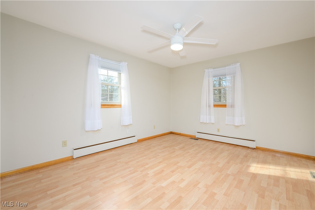 6571 Peck Road Ravenna, OH 44266 - Photo 10 of 44 Master bedroom with natural light, ceiling fan, mechanical blinds and laminate floor.