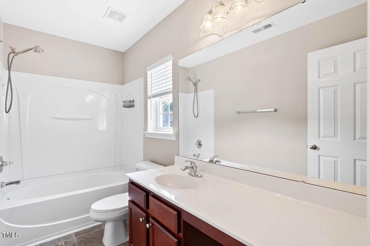 120 Ryder Cup Circle Raleigh, NC 27603 - Photo 12 of 18 a bathroom with a sink toilet a mirror and shower