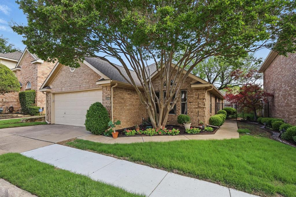a view of a house with a yard and a large tree