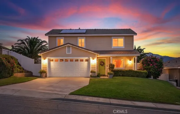 a front view of a house with a garden and a garage