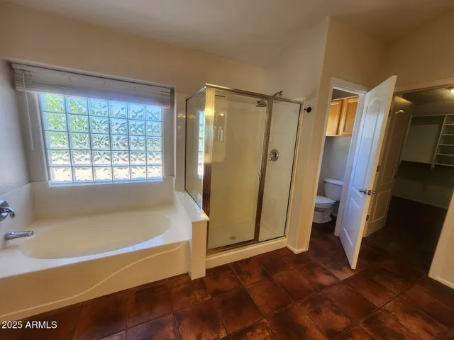 a bathroom with a toilet a sink and a window