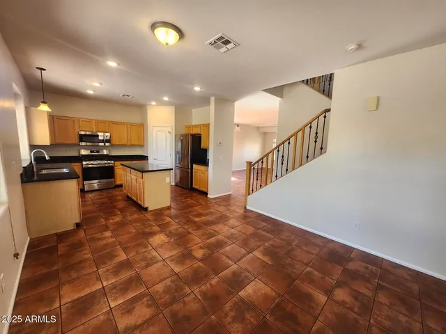 a kitchen with granite countertop a sink cabinets and stainless steel appliances
