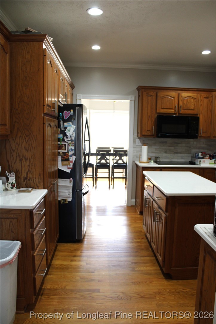 573 Porter Road Hope Mills, NC 28348 - Photo 6 of 29 a open kitchen with stainless steel appliances kitchen island granite countertop a stove top oven a sink dishwasher and a dining table with wooden floor
