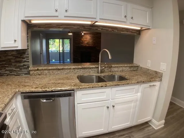 a kitchen with kitchen island granite countertop a sink and a refrigerator