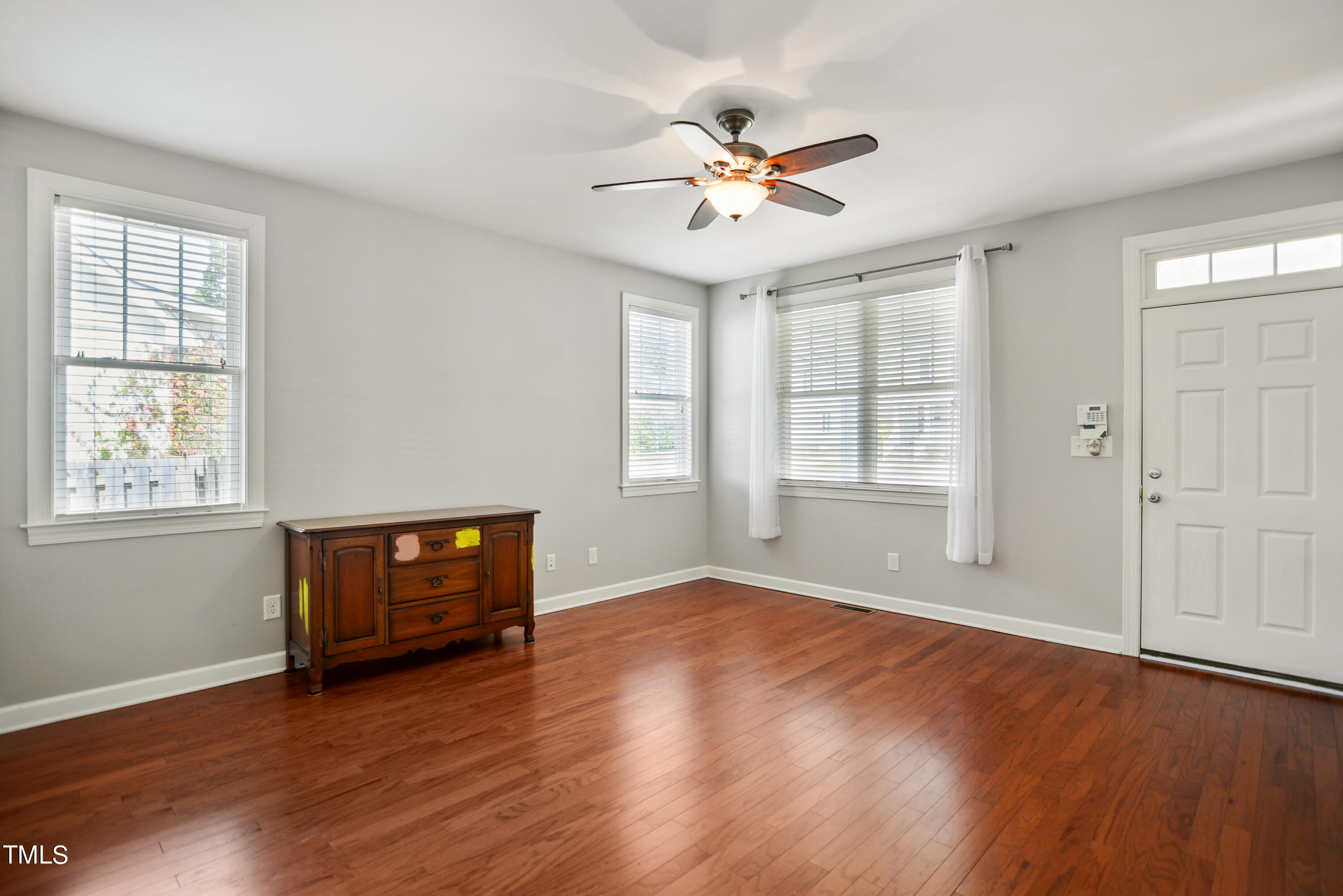 207 Idlewild Avenue Raleigh, NC 27601 - Photo 3 of 14 a view of an empty room with window hardwood floor and a ceiling fan