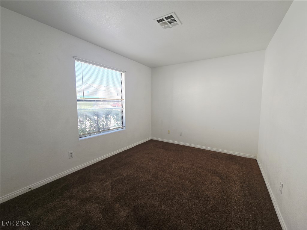 5211 South Lindell Road, Unit 104 Las Vegas, NV 89118 - Photo 8 of 12 Empty room featuring dark colored carpet