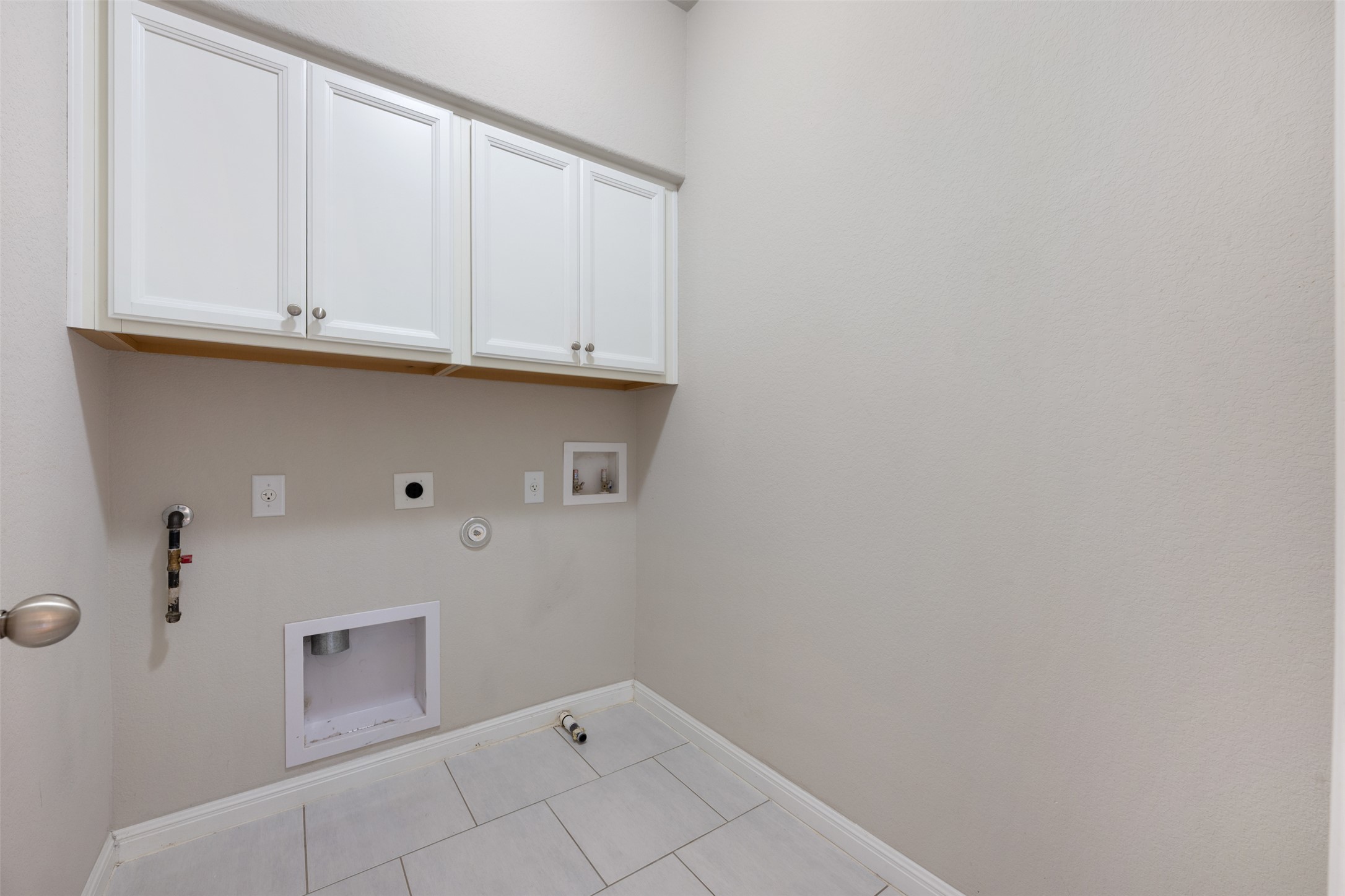 211 Parable Cove Pflugerville, TX 78660 - Photo 34 of 40 Utility area featuring white shaker-style cabinetry, square tile flooring, and neutral wall tones