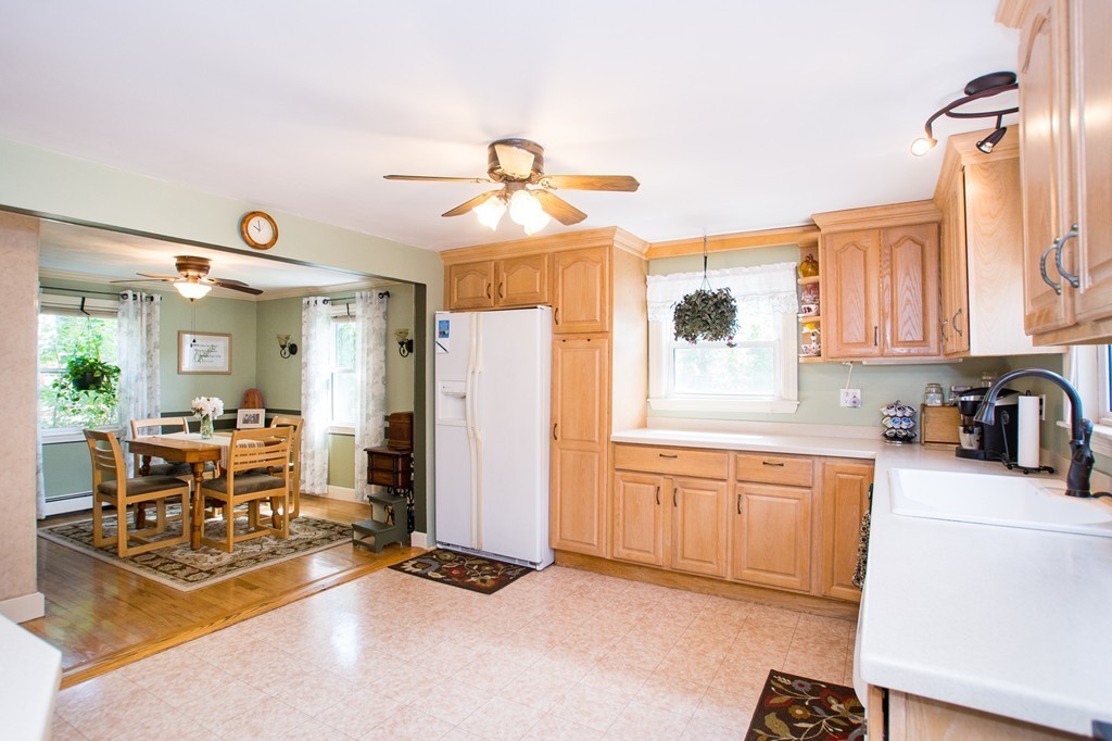 69 Lakeview Terrace Waltham, MA 02451 - Photo 5 of 17 a kitchen with stainless steel appliances granite countertop a refrigerator a sink dishwasher a dining table and chairs with wooden floor