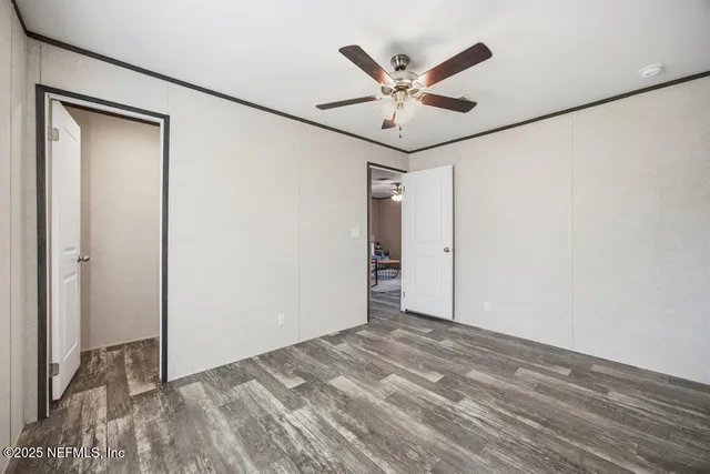 a view of a room with wooden floor and white walls