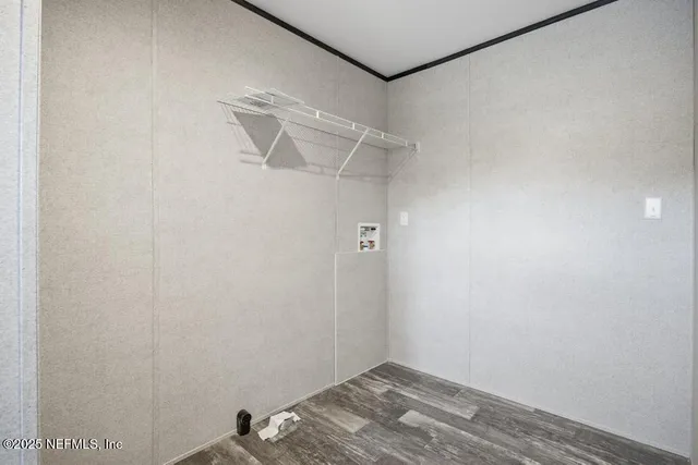 a view of a livingroom with wooden floor and white walls