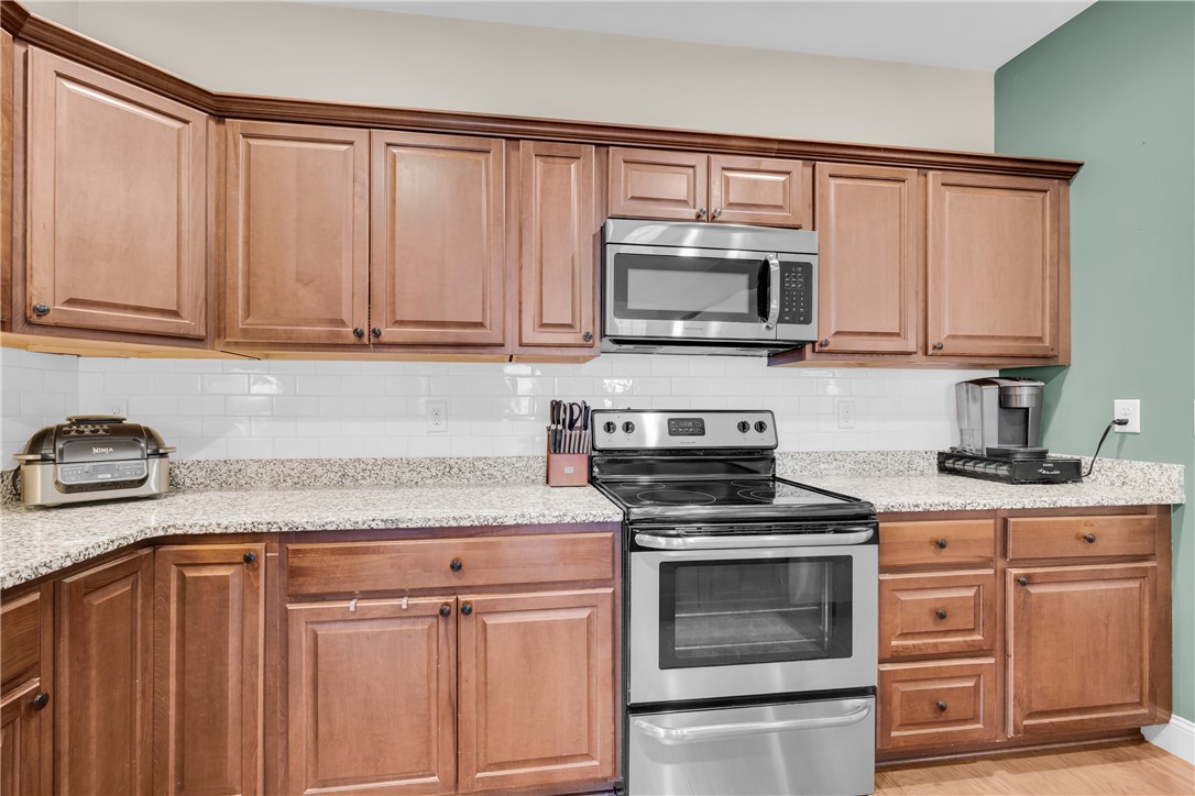 5 Drakeford Court Anderson, SC 29621 - Photo 23 of 46 Rich wood cabinetry surrounds integrated appliances on durable granite countertops.