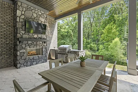 a view of a patio with table and chairs and couches with wooden floor and fence