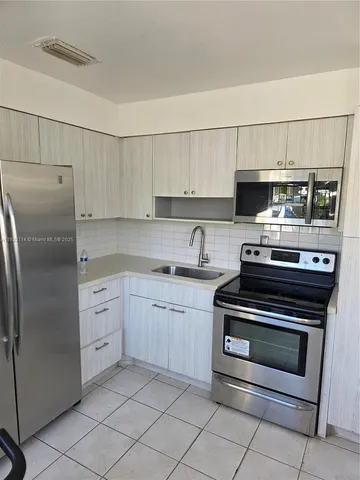 a kitchen with cabinets appliances and a sink