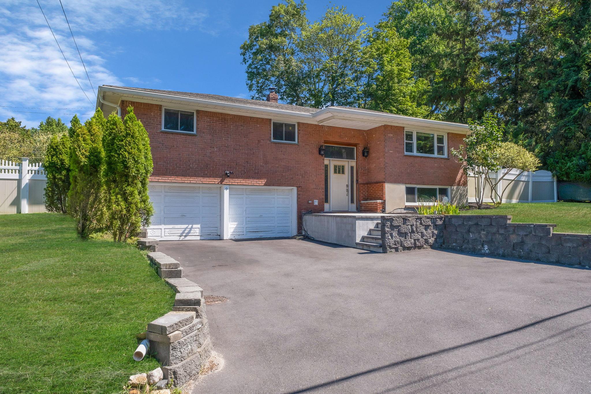 a view of a house with a yard and a large tree