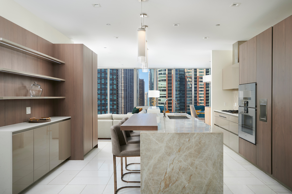 363 East Wacker Drive, Unit 1506 Chicago, IL 60601 - Photo 14 of 34 a large kitchen with a table chairs refrigerator and cabinets