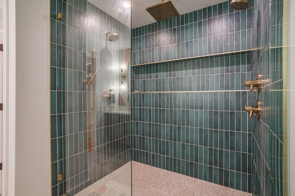 6700 Fortune Road Fort Worth, TX 76116 - Photo 27 of 40 Spacious walk-in shower featuring teal vertical subway tile, gold-tone fixtures, a rainfall showerhead, and integrated shelving