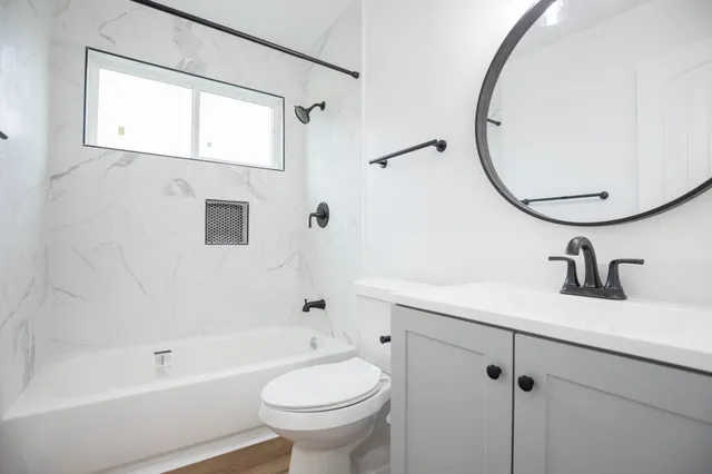 a bathroom with a sink a toilet and a mirror