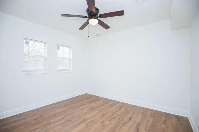 an empty room with a window and a ceiling fan
