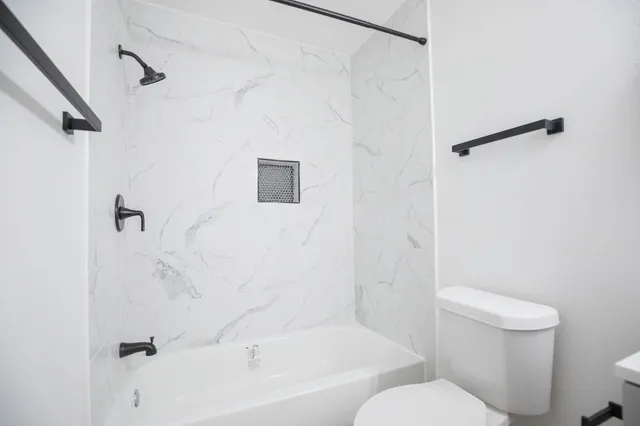 a bathroom with a toilet and a bathtub