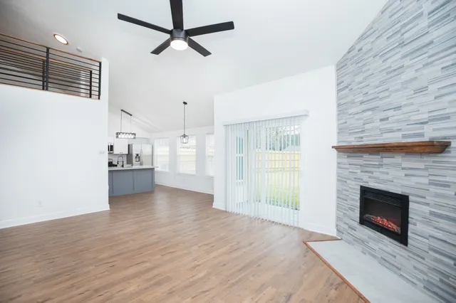 a view of a livingroom with wooden floor and a fireplace