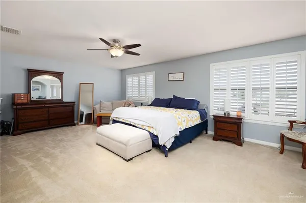 a spacious bedroom with a bed dresser and a window