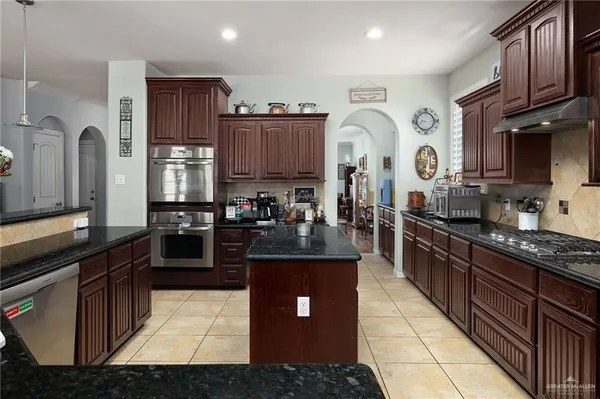 a kitchen with stainless steel appliances granite countertop a stove a sink dishwasher and a refrigerator