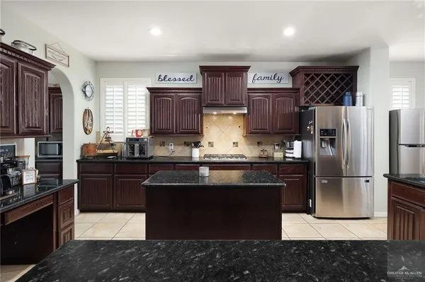 a kitchen with stainless steel appliances granite countertop a refrigerator stove a sink and dishwasher