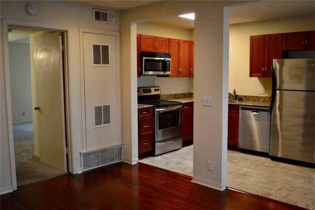 a view of an empty room with wooden floor