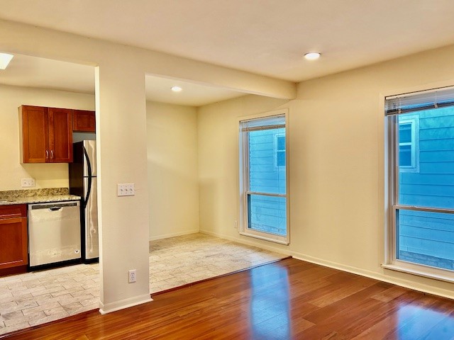 2800 Cole Street, Unit 202C Austin, TX 78705 - Photo 6 of 16 a view of a kitchen with a fridge and wooden floor