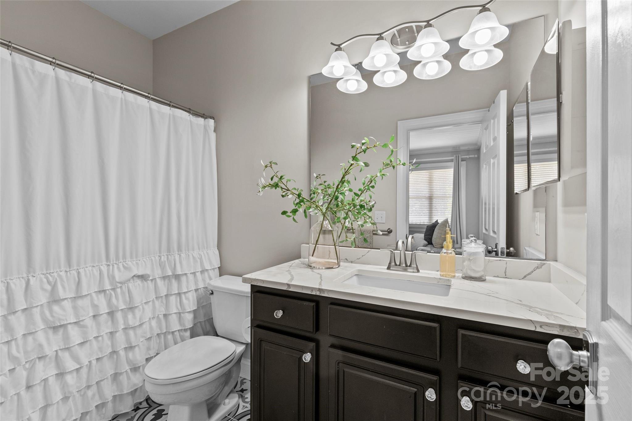 5601 Fairview Road, Unit 24 Charlotte, NC 28209 - Photo 30 of 38 a bathroom with a sink a toilet and mirror