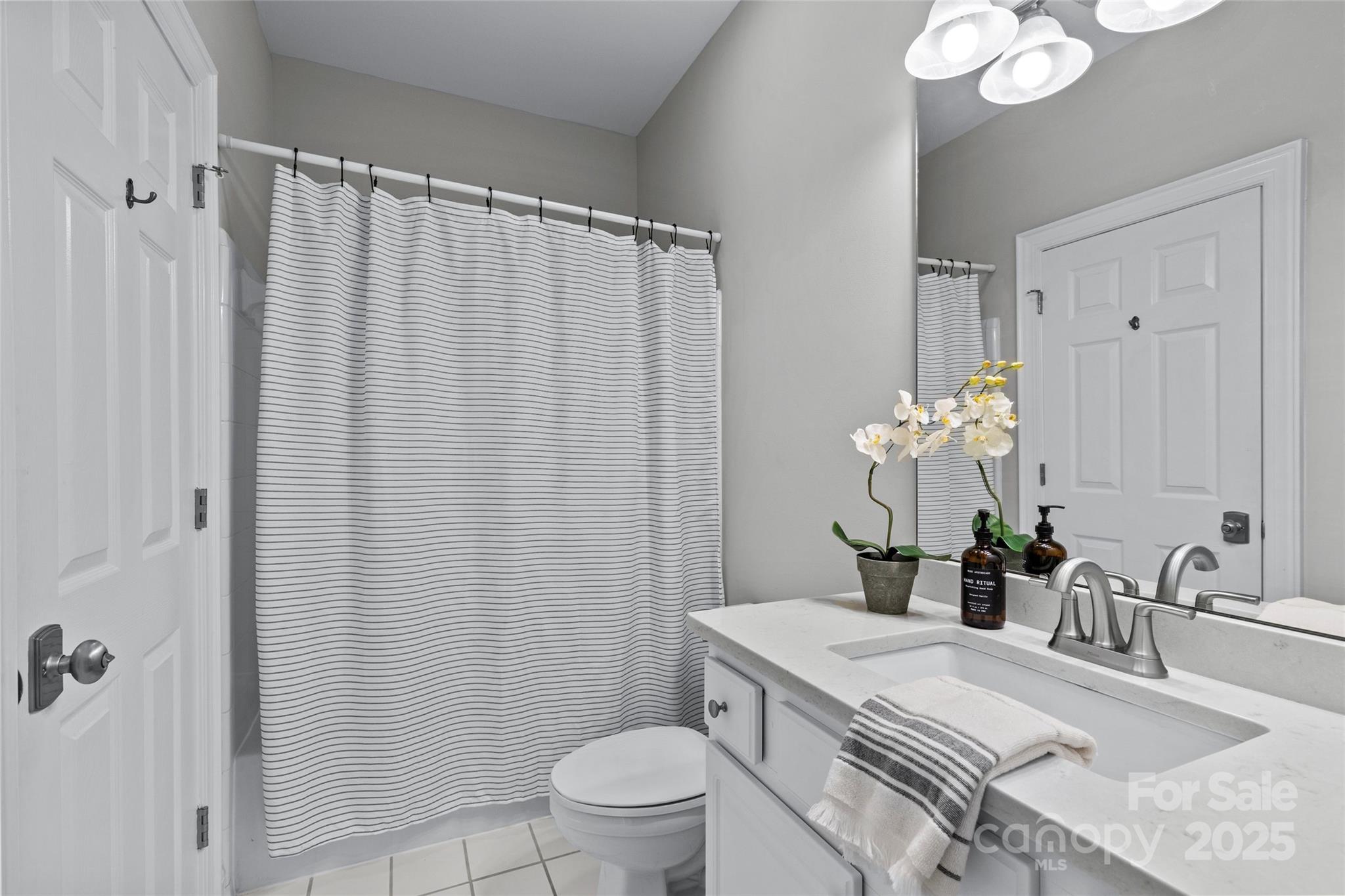 5601 Fairview Road, Unit 24 Charlotte, NC 28209 - Photo 7 of 38 a bathroom with a granite countertop sink a toilet and shower curtain