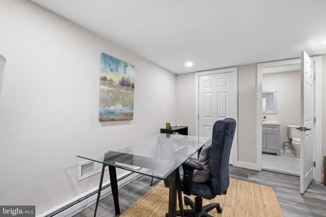 a view of a workspace with furniture and wooden floor