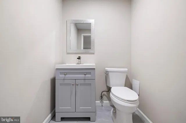 a bathroom with a toilet a sink and mirror