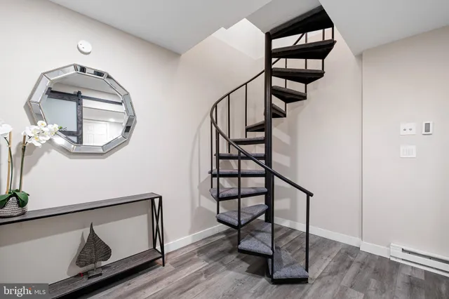 a view of staircase with a potted plant on a table and chairs