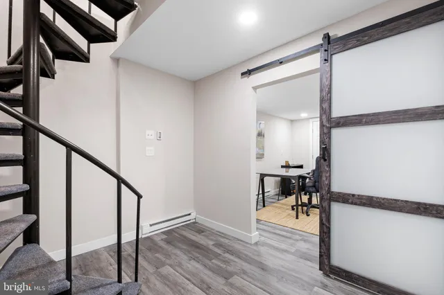 a view of a hallway with wooden floor and furniture