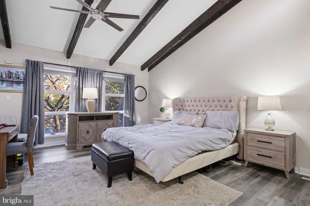 a bedroom with a bed a dresser next to a window