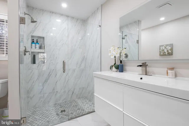 a bathroom with a sink a mirror and shower