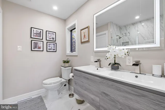 a bathroom with a sink mirror and toilet