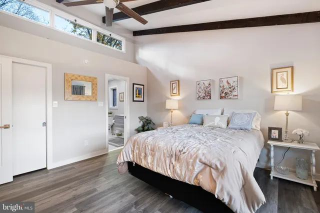 a bedroom with a large bed and a lamp on the dresser