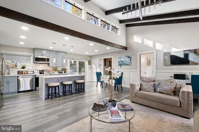 a living room with stainless steel appliances kitchen island granite countertop furniture and a large window