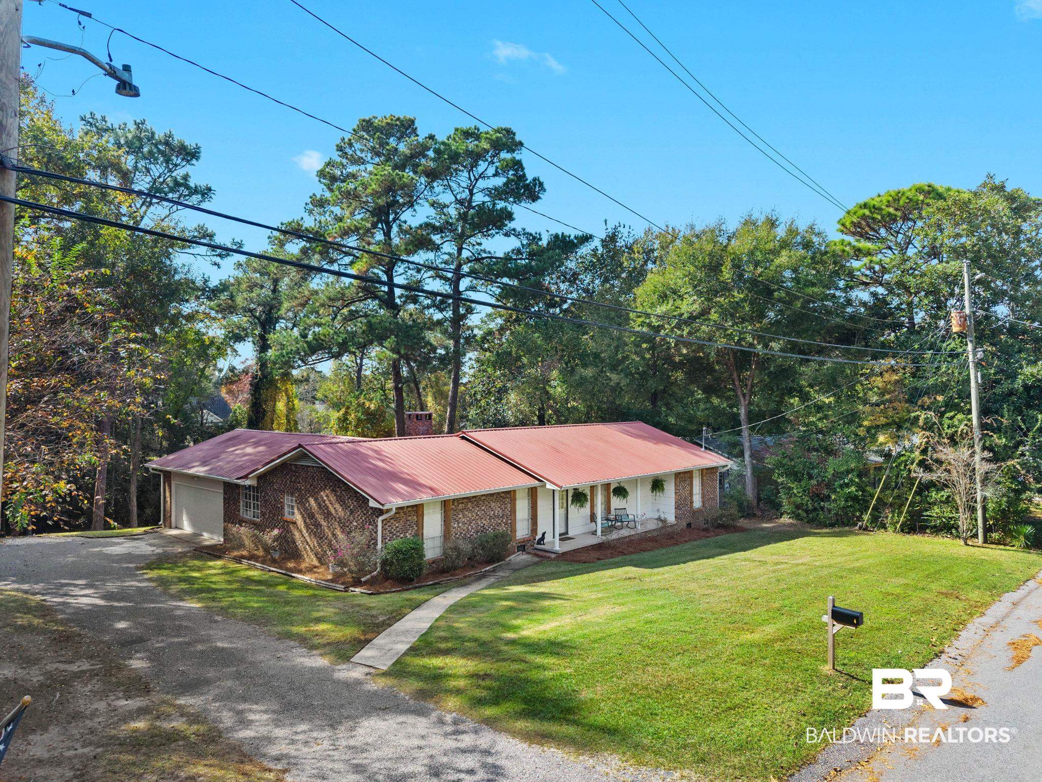 4 Rally Road Spanish Fort, AL 36527 - Photo 5 of 41 View of front of property with brick siding, a metal roof, driveway, a front lawn, and a porch