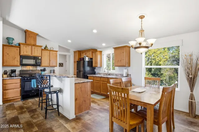 a open dining room with stainless steel appliances furniture a window and kitchen view