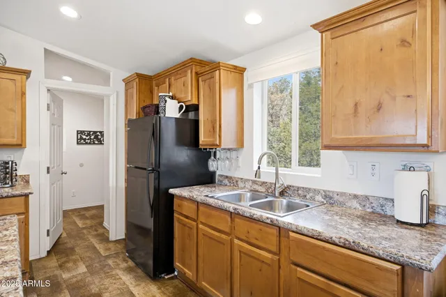 a kitchen with stainless steel appliances granite countertop a refrigerator and a sink