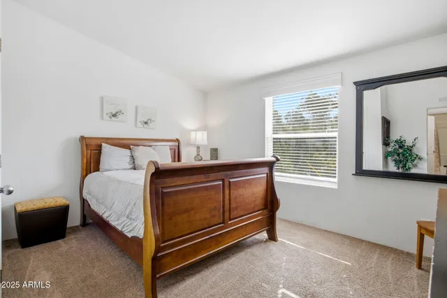 a bed sitting in a bedroom next to a window