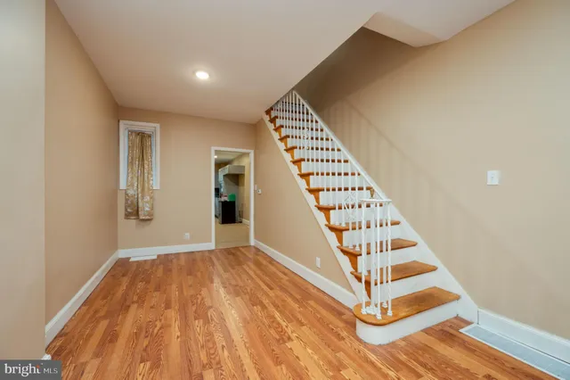 a view of a hallway with wooden floor and staircase