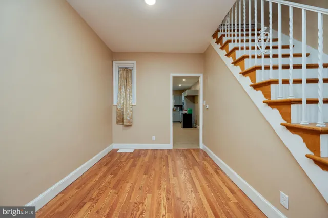 a view of a hallway with wooden floor and staircase